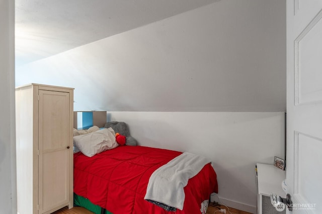 bedroom featuring baseboards and vaulted ceiling