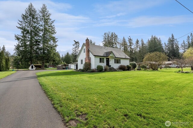 view of front of property with a front yard and a chimney