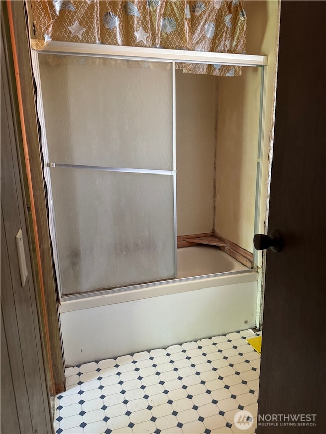 full bath with shower / bath combination with glass door and tile patterned floors