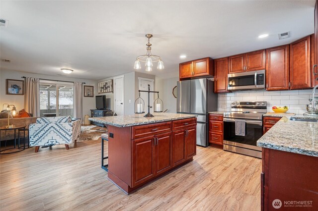 207 Harmon St, Waitsburg, WA 99361 - kitchen featuring decorative backsplash, open floor plan, light wood-type flooring, and appliances with stainless steel finishes