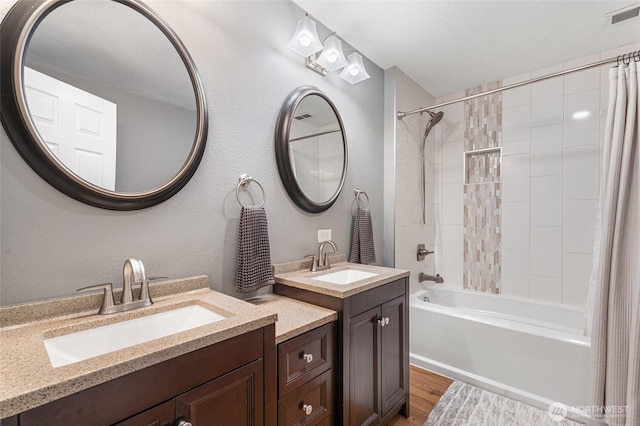 207 Harmon St, Waitsburg, WA 99361 - full bathroom with a sink, visible vents, shower / bath combination with curtain, and wood finished floors