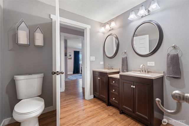 207 Harmon St, Waitsburg, WA 99361 - bathroom featuring toilet, wood finished floors, baseboards, and vanity