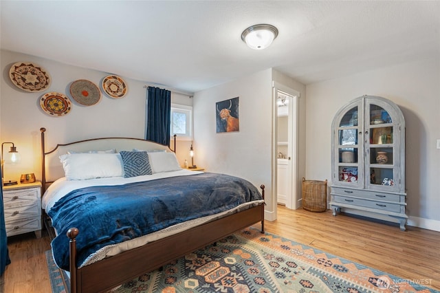 207 Harmon St, Waitsburg, WA 99361 - bedroom featuring baseboards, wood finished floors, and ensuite bathroom