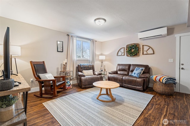 207 Harmon St, Waitsburg, WA 99361 - living area with dark wood finished floors, baseboards, a wall mounted air conditioner, and a textured ceiling
