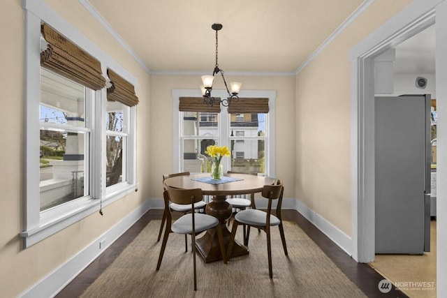 902 Wood Ave, Sumner, WA 98390 - dining room featuring dark wood-type flooring, ornamental molding, baseboards, and a chandelier