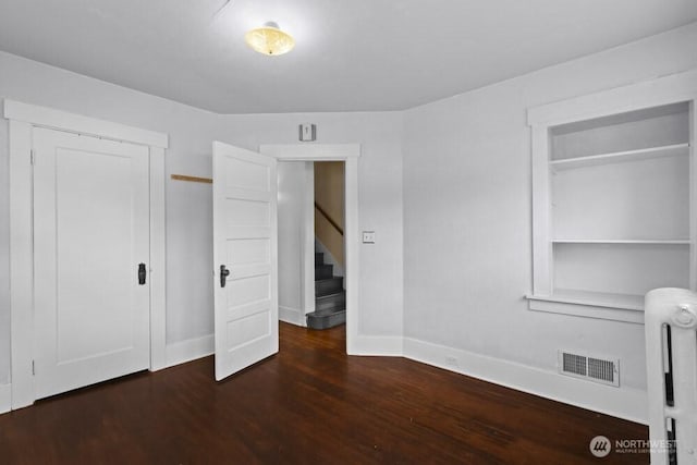 902 Wood Ave, Sumner, WA 98390 - unfurnished bedroom with a closet, baseboards, radiator heating unit, visible vents, and wood finished floors
