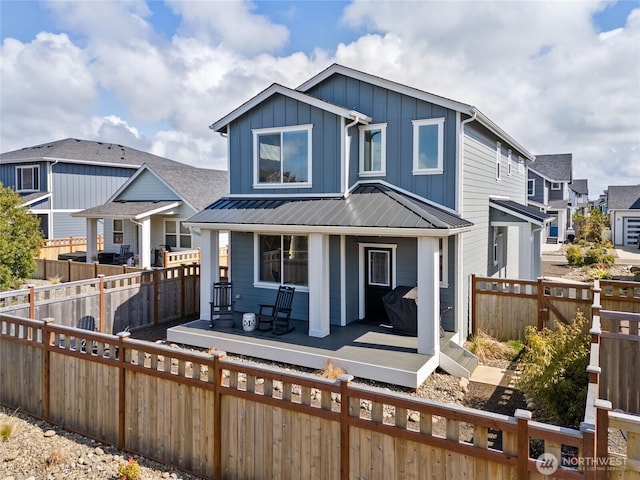 441 Lupine Ln SW, Ocean Shores, WA 98569 - view of front of house with metal roof, a fenced backyard, board and batten siding, and a residential view