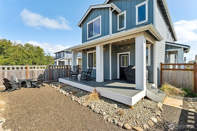441 Lupine Ln SW, Ocean Shores, WA 98569 - rear view of property featuring a wooden deck, a fire pit, a fenced backyard, and board and batten siding