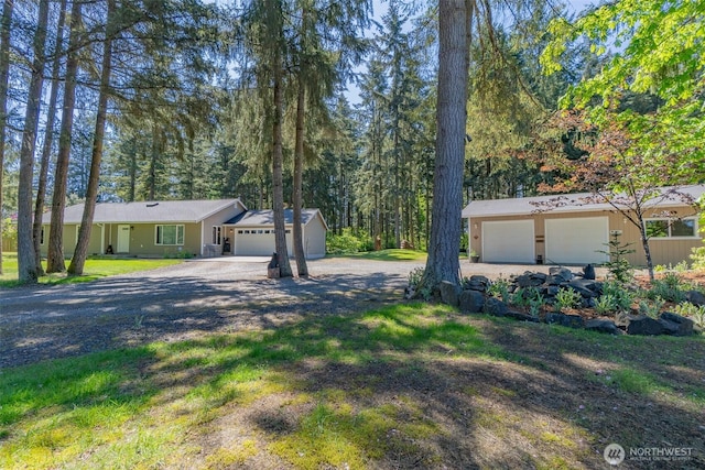 24620 36th Avenue Ct E, Spanaway, WA 98387 - view of front of house with dirt driveway, a garage, and an outbuilding