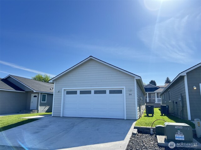 ranch-style home with central AC, a garage, a front lawn, and an outbuilding