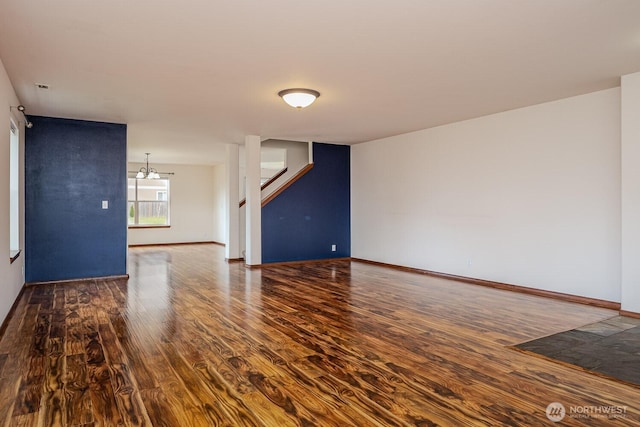 402 Easy St SE, Rainier, WA 98576 - unfurnished living room featuring baseboards, wood finished floors, an inviting chandelier, and stairway