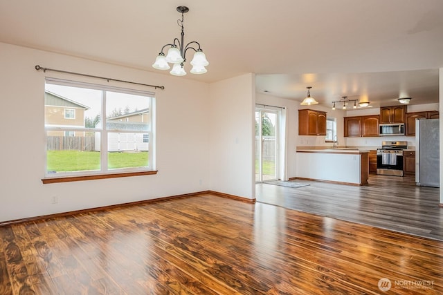 402 Easy St SE, Rainier, WA 98576 - unfurnished living room with dark wood-style flooring, a wealth of natural light, and an inviting chandelier