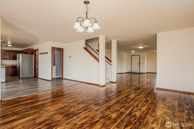 402 Easy St SE, Rainier, WA 98576 - unfurnished living room featuring baseboards, dark wood-style flooring, a chandelier, and stairway