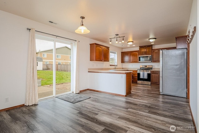 402 Easy St SE, Rainier, WA 98576 - kitchen with light countertops, a peninsula, appliances with stainless steel finishes, dark wood-type flooring, and a sink