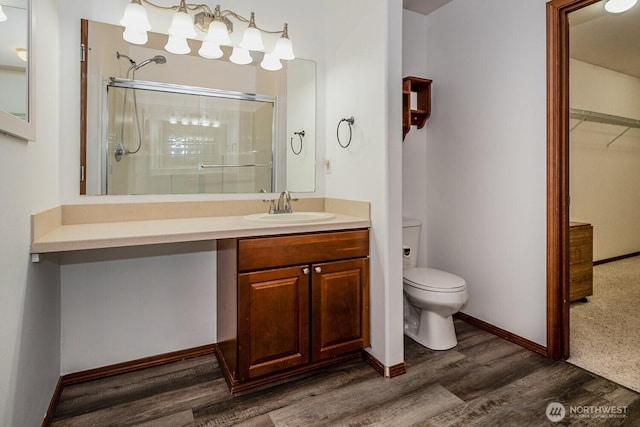 402 Easy St SE, Rainier, WA 98576 - bathroom featuring toilet, vanity, a shower stall, wood finished floors, and baseboards