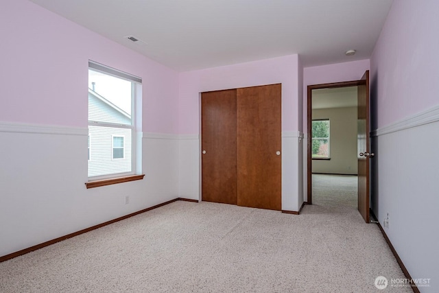 402 Easy St SE, Rainier, WA 98576 - unfurnished bedroom featuring a closet, carpet flooring, visible vents, and multiple windows