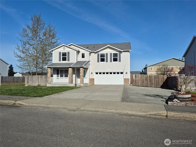 402 Easy St SE, Rainier, WA 98576 - traditional-style home with an attached garage, covered porch, fence, and concrete driveway