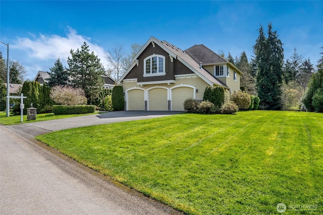 view of front of house with a front lawn, a garage, and driveway