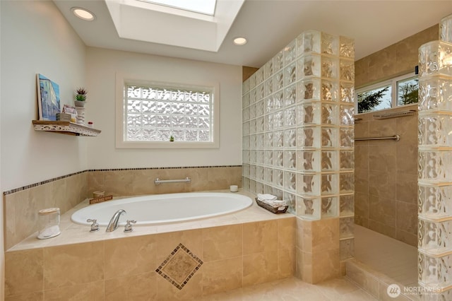 bathroom featuring a skylight, a walk in shower, recessed lighting, and a garden tub