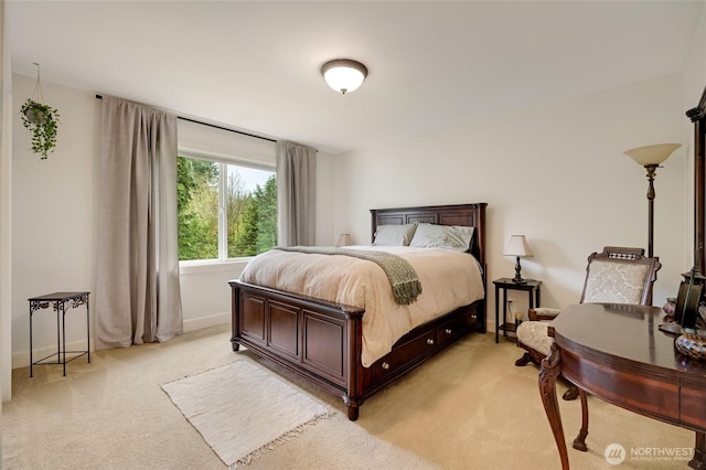 bedroom featuring light colored carpet and baseboards