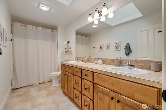 bathroom featuring tile patterned floors, double vanity, a sink, and toilet