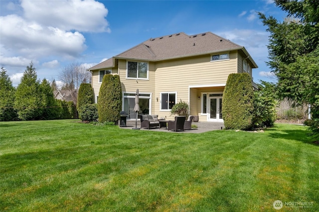 rear view of property featuring french doors, an outdoor hangout area, a patio area, and a yard