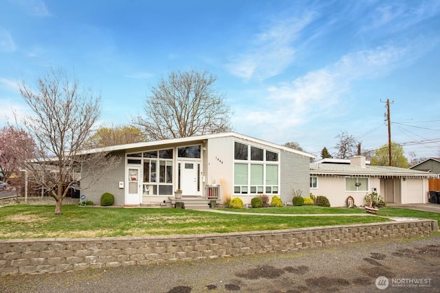 1444 SE Central Ave, College Place, WA 99324 - mid-century home featuring roof mounted solar panels, driveway, a front yard, and a garage