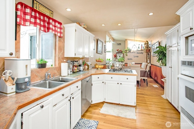 1444 SE Central Ave, College Place, WA 99324 - kitchen featuring appliances with stainless steel finishes, white cabinets, a sink, and a peninsula