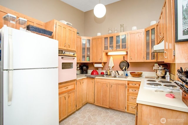 1444 SE Central Ave, College Place, WA 99324 - kitchen featuring light countertops, a sink, glass insert cabinets, under cabinet range hood, and white appliances