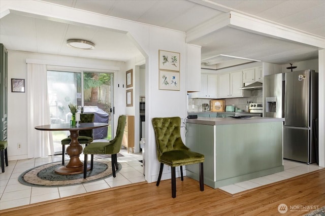 3800 Saratoga Rd, Langley, WA 98260 - kitchen with arched walkways, a peninsula, under cabinet range hood, stainless steel appliances, and backsplash