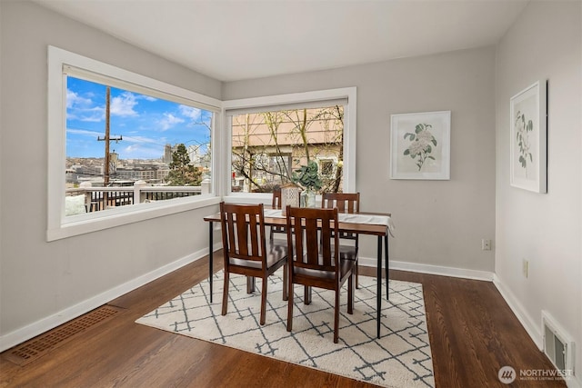 dining area with visible vents, baseboards, and wood finished floors