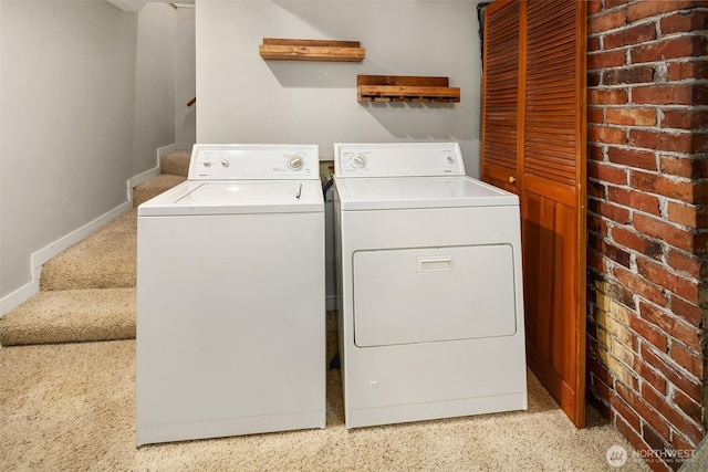 laundry area with baseboards and washer and dryer