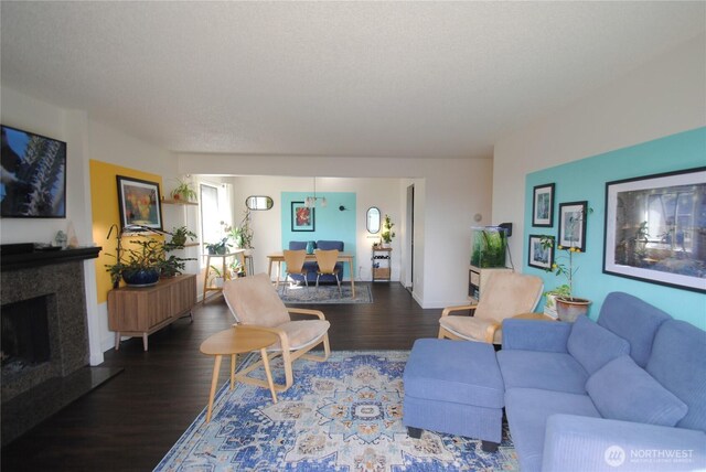 living area featuring a textured ceiling, wood finished floors, and a premium fireplace