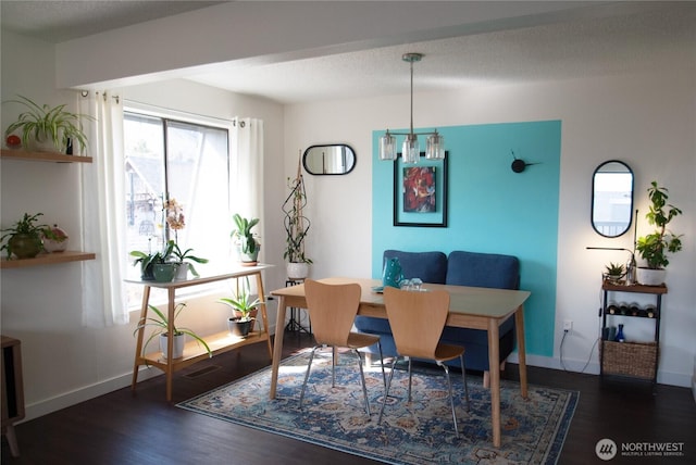 dining area featuring baseboards, a textured ceiling, and wood finished floors