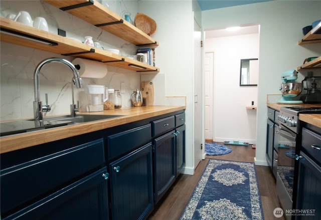 kitchen with a sink, open shelves, tasteful backsplash, stainless steel range with electric stovetop, and butcher block counters