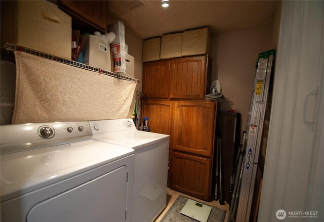 laundry area with cabinet space, washing machine and dryer, and visible vents