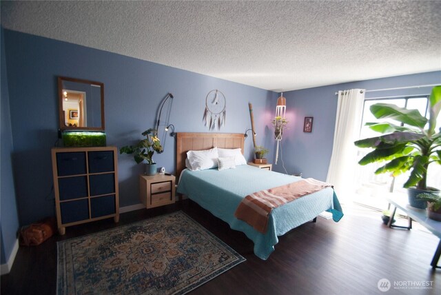 bedroom with a textured ceiling and wood finished floors