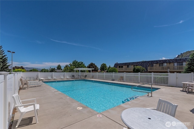 community pool with a patio and fence