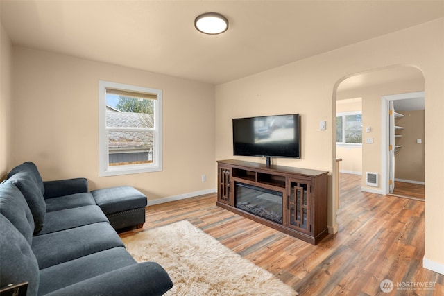1427 Garrison Ave, Port Orchard, WA 98366 - living room with baseboards, visible vents, wood finished floors, and arched walkways