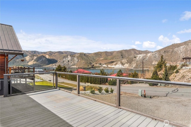 wooden deck with a water and mountain view