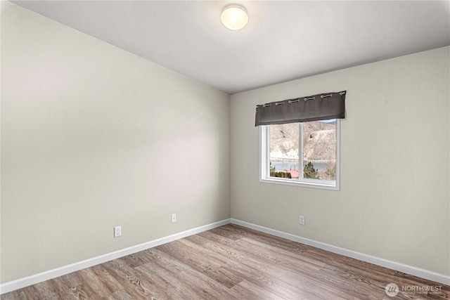 empty room featuring baseboards and wood finished floors