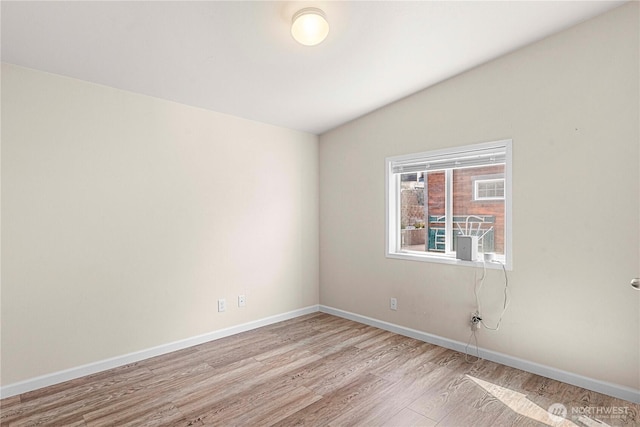 spare room with baseboards and light wood-style floors