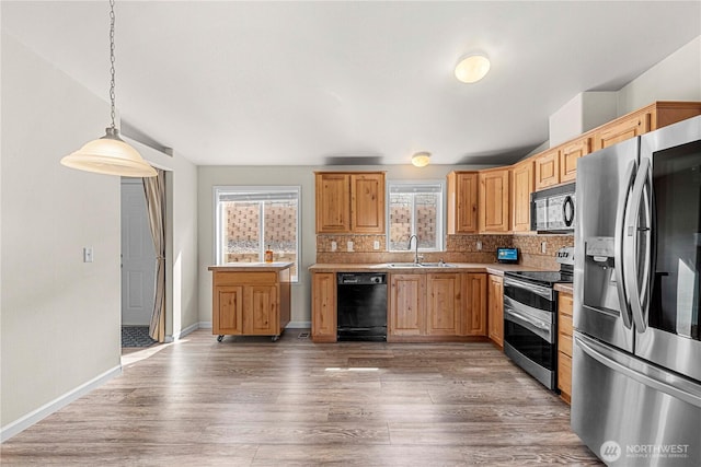 kitchen with backsplash, a sink, black appliances, and light wood finished floors