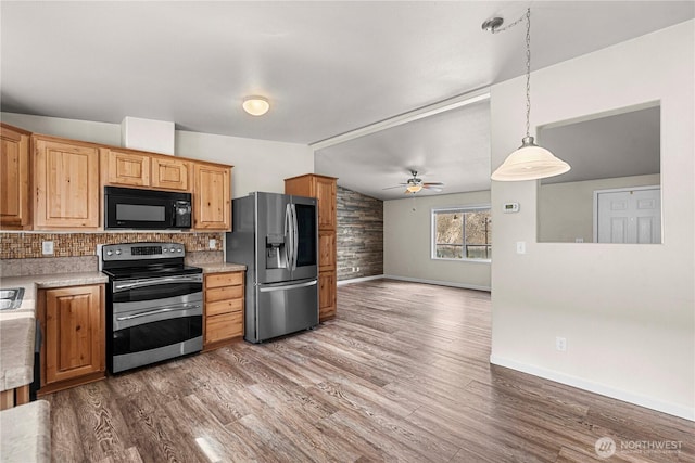 kitchen with lofted ceiling, backsplash, wood finished floors, and appliances with stainless steel finishes