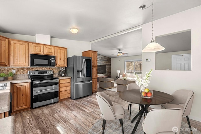kitchen with decorative backsplash, ceiling fan, wood finished floors, stainless steel appliances, and lofted ceiling