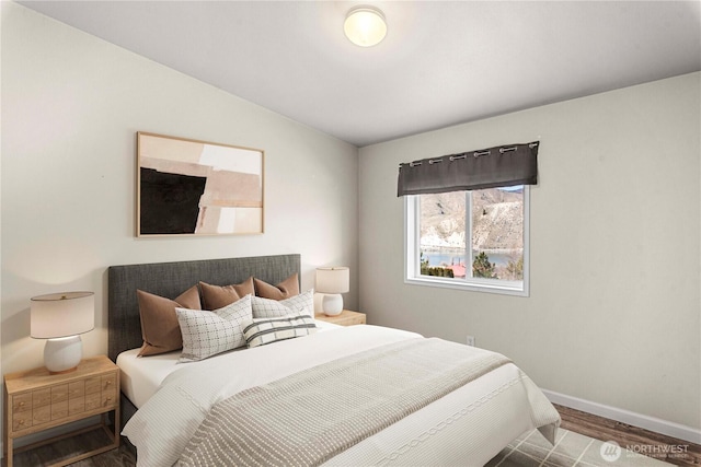 bedroom featuring baseboards and wood finished floors