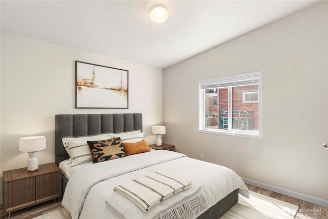 bedroom with baseboards and wood finished floors