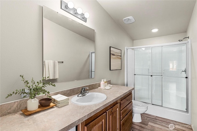 full bath featuring wood finished floors, toilet, vanity, and an enclosed shower