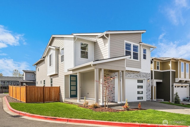 27215 106th Ave SE, Kent, WA 98030 - view of front of house featuring stone siding, fence, a front lawn, an attached garage, and driveway
