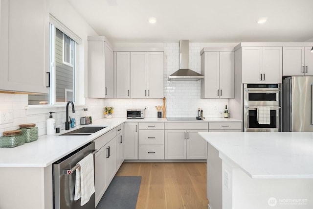 27215 106th Ave SE, Kent, WA 98030 - kitchen with wall chimney range hood, light countertops, appliances with stainless steel finishes, light wood finished floors, and a sink